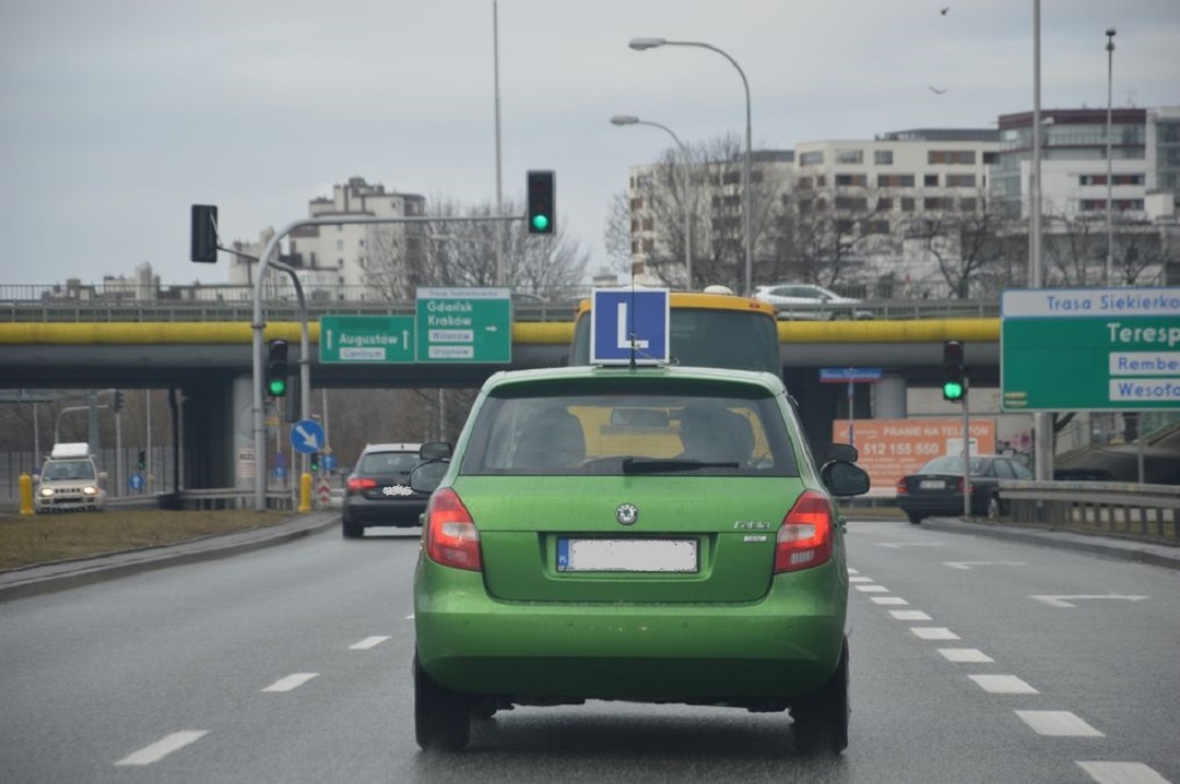 zielony samochód nauka jazdy z symbolem L na dachu.